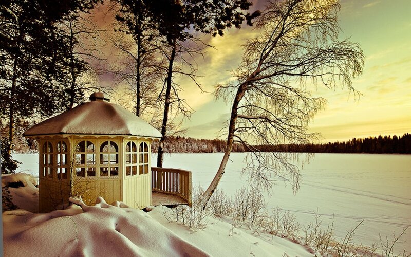 Snowy gazebo by frozen lake