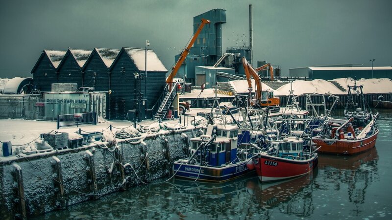 Snowy harbor with fishing boats