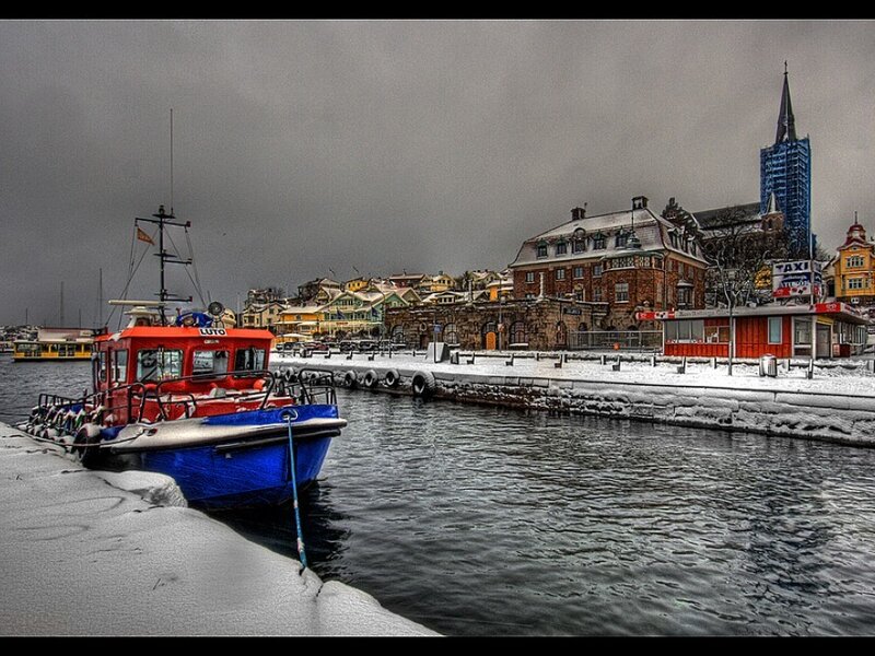 Snowy harbor with red boat