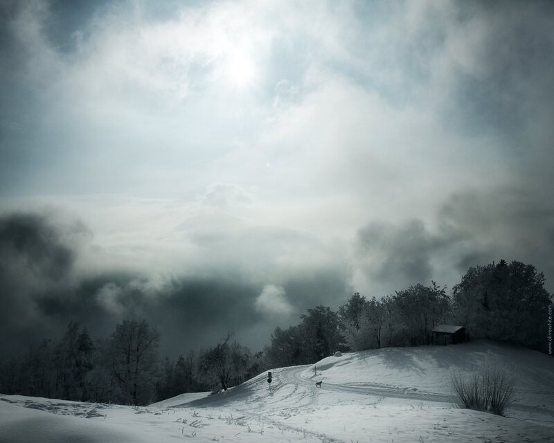 Snowy hill under cloudy sky