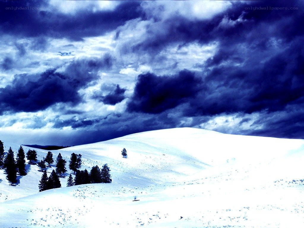 Snowy hill under stormy sky