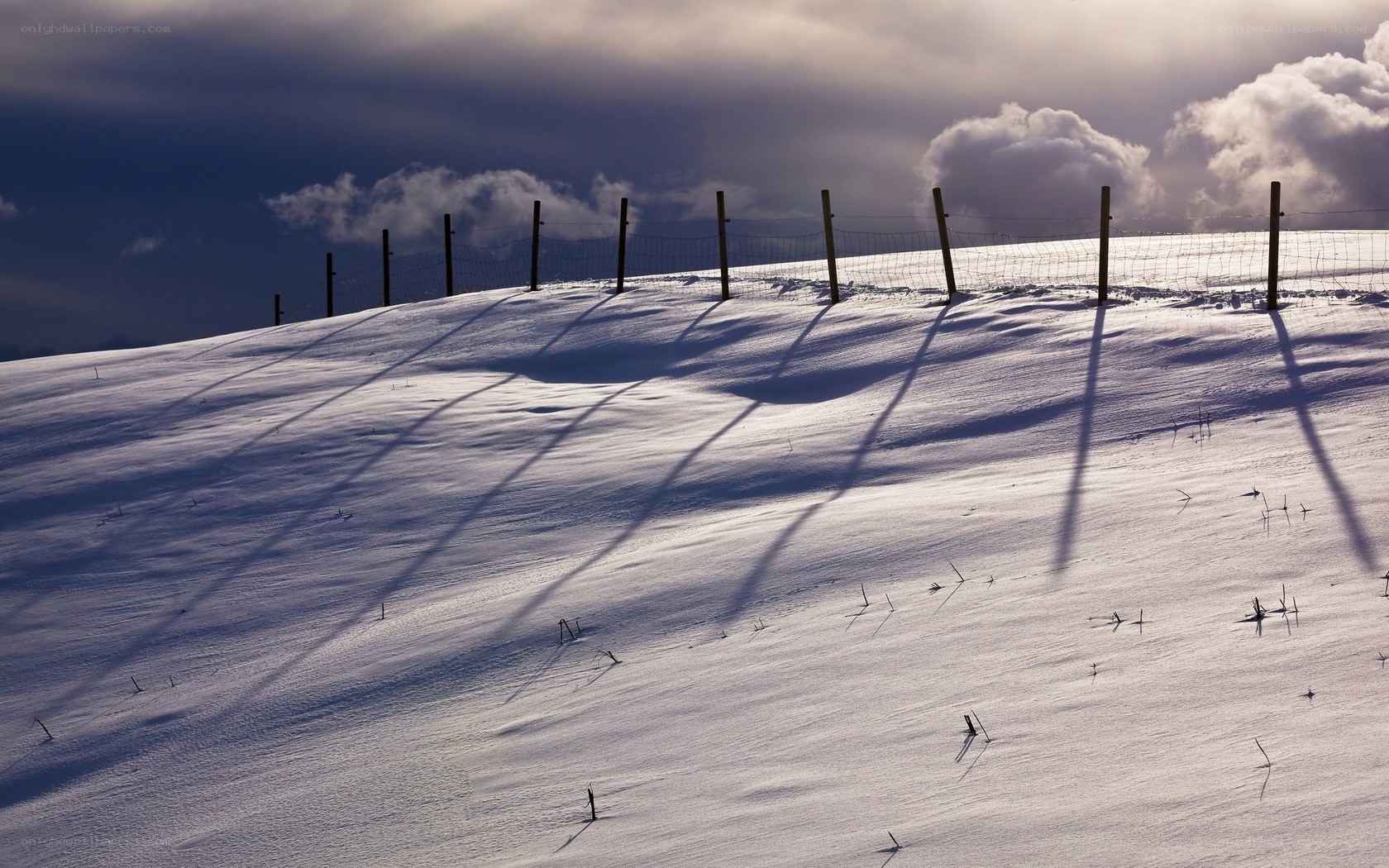 Snowy Hill with Fence Shadows