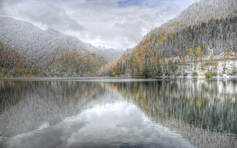 Snowy lake in autumn mountains
