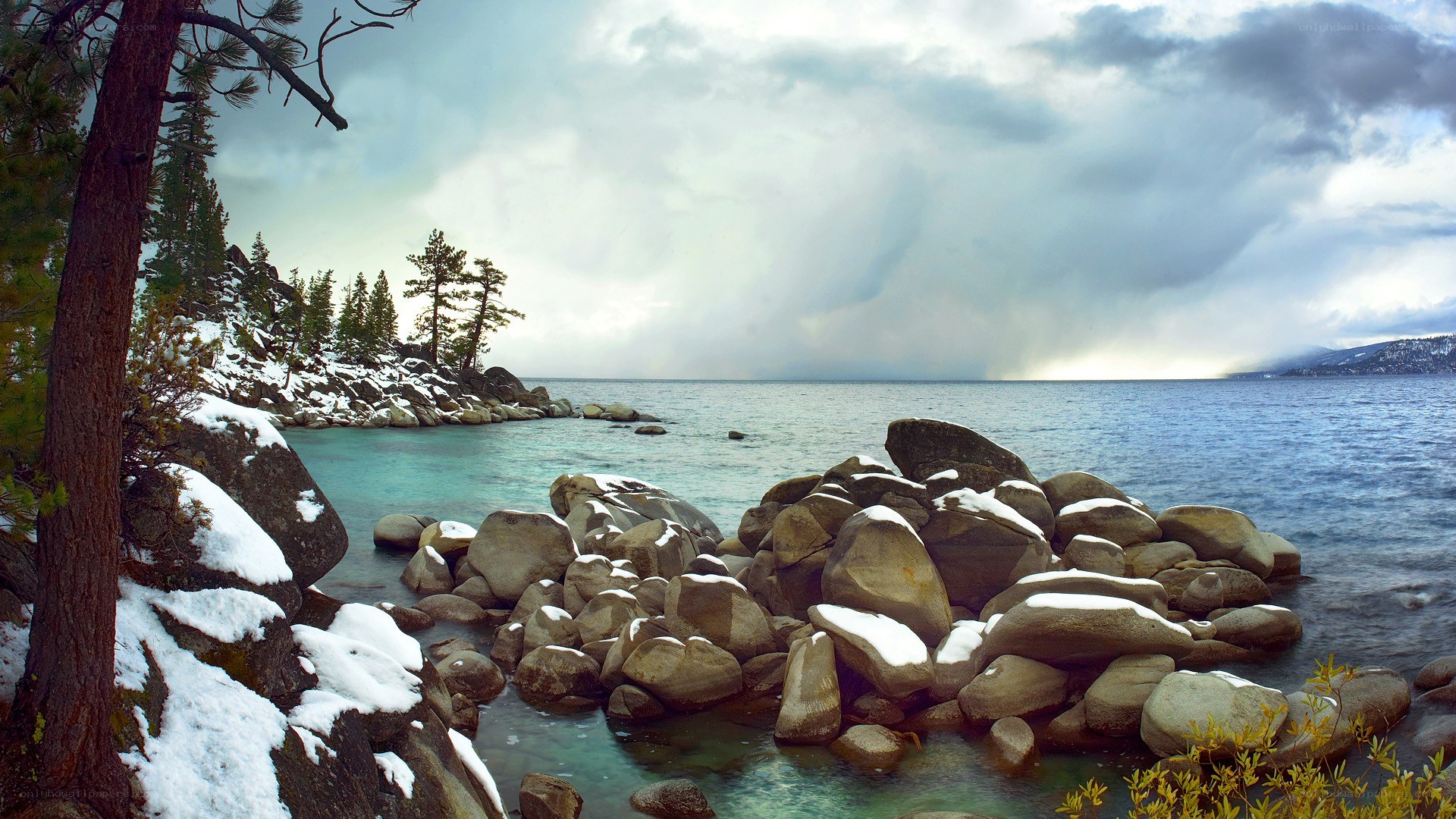 Snowy lake shore with storm clouds