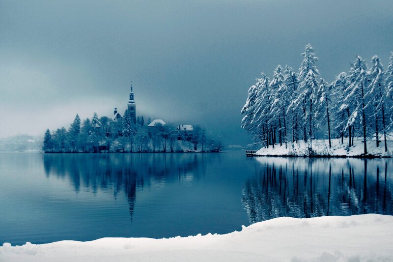 Snowy lake with island church
