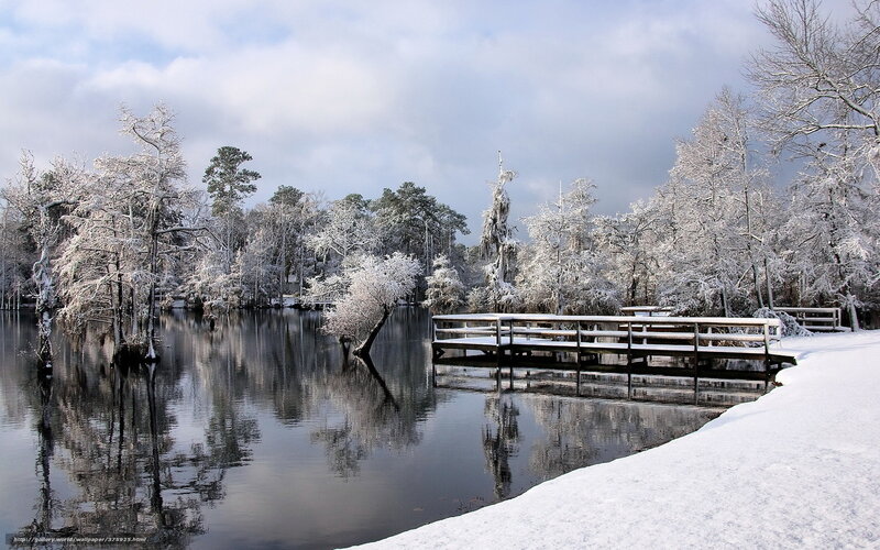 Snowy lake with wooden bridge