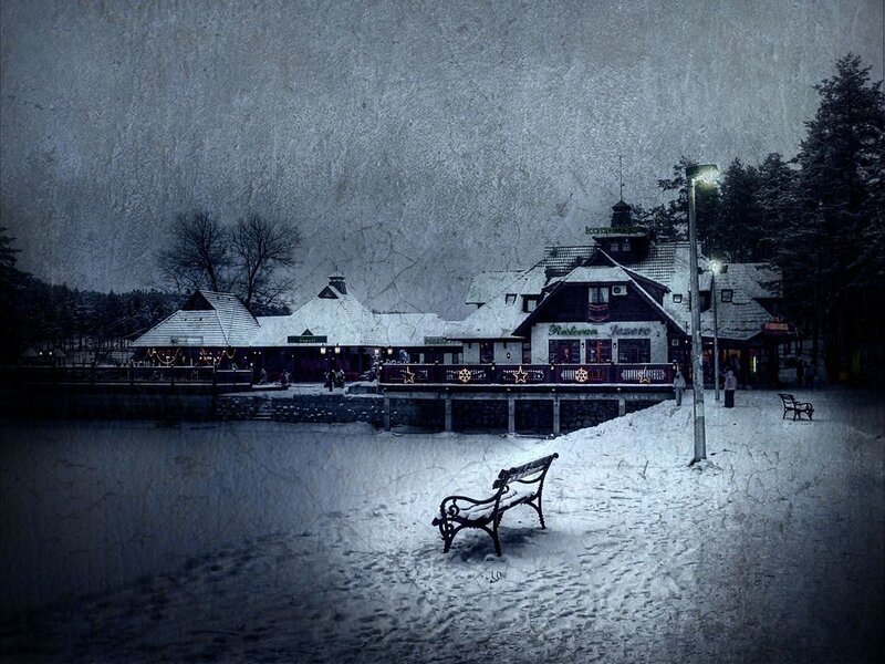 Snowy lakefront village at night