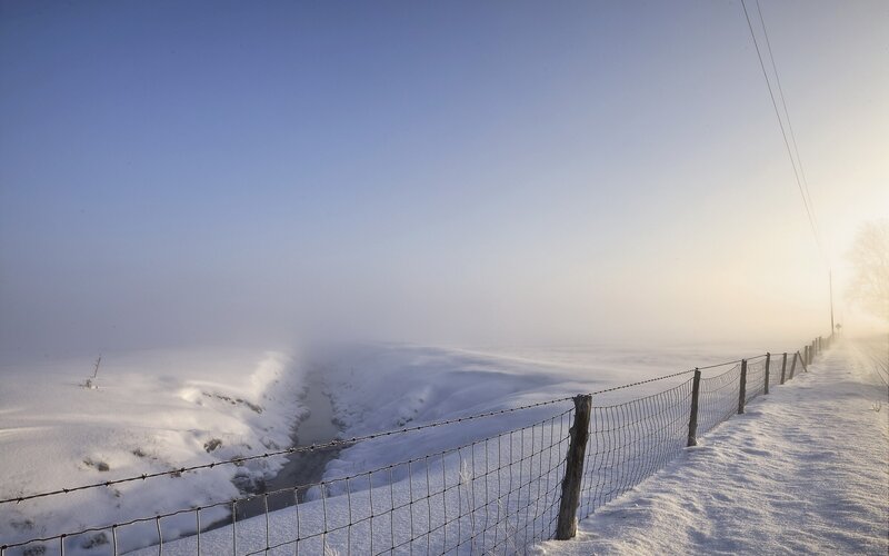 Snowy landscape with fence