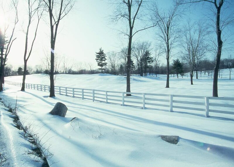 Snowy landscape with white fence