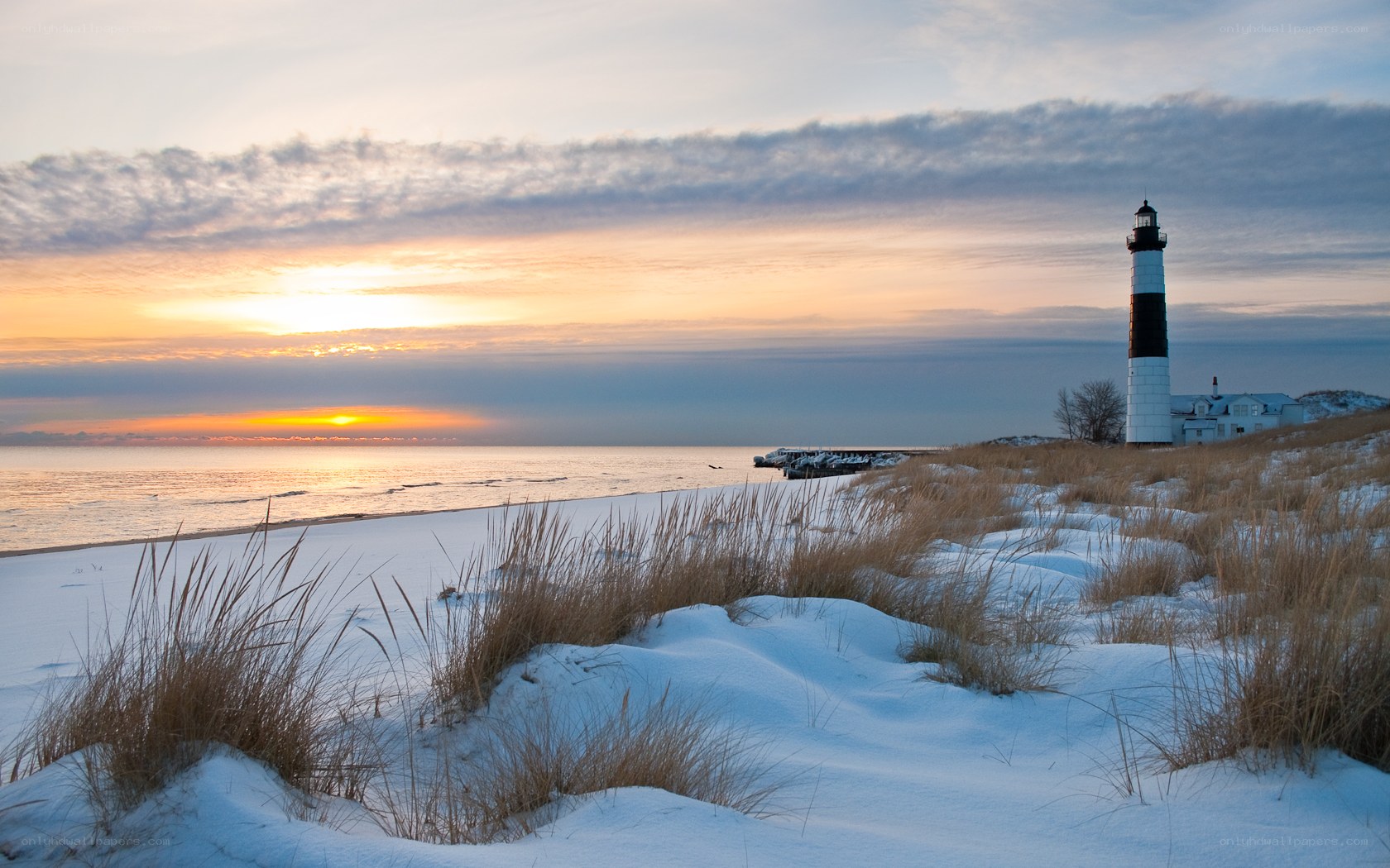 Snowy lighthouse at sunset