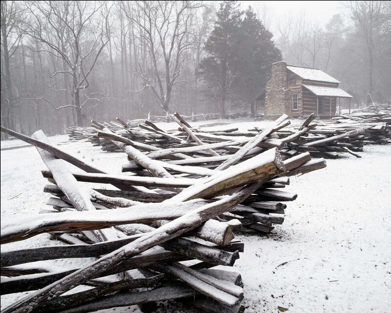 Snowy log fence and cabin