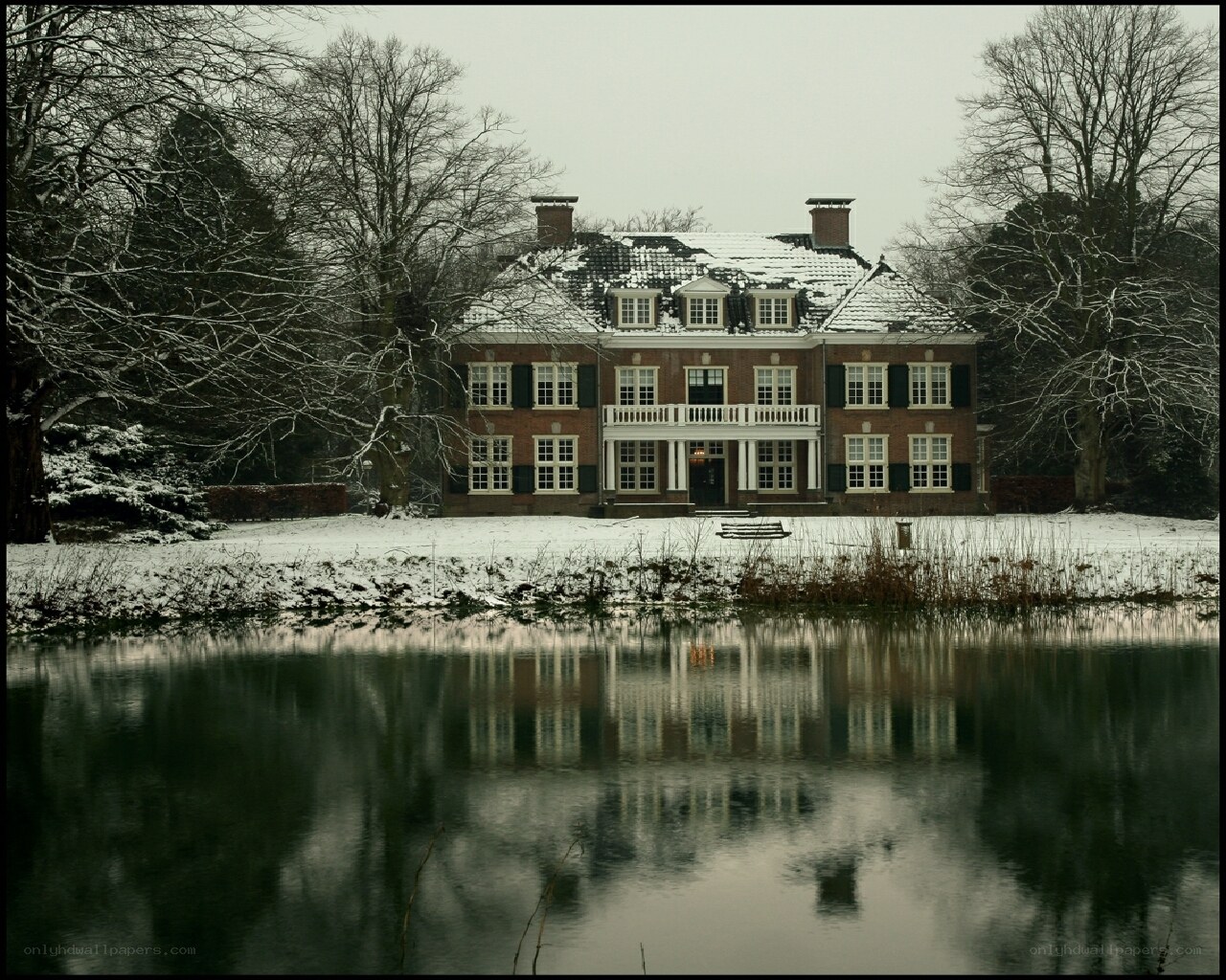 Snowy mansion by a pond