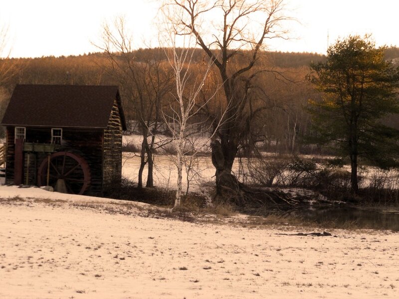 Snowy mill by a river