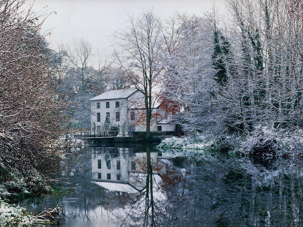 Snowy mill by a river