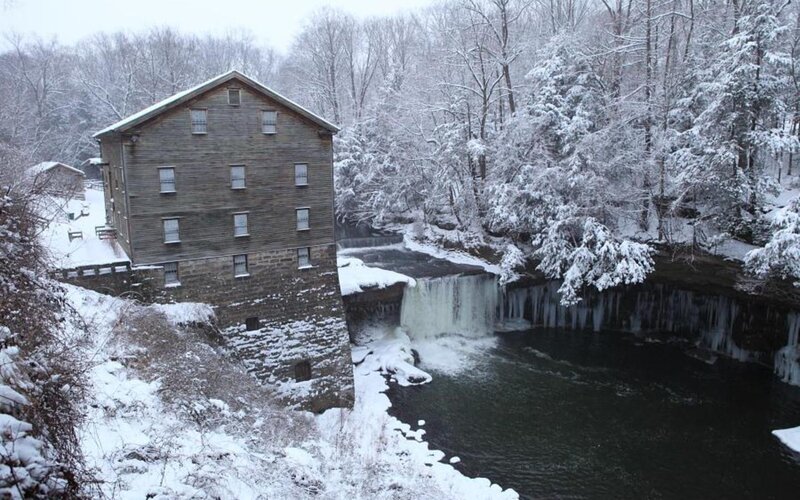 Snowy mill by a waterfall