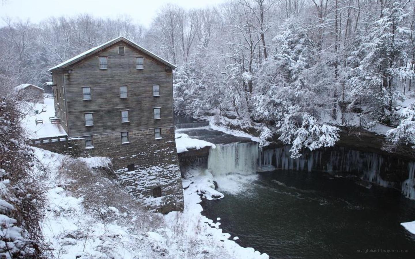 Snowy mill by a waterfall