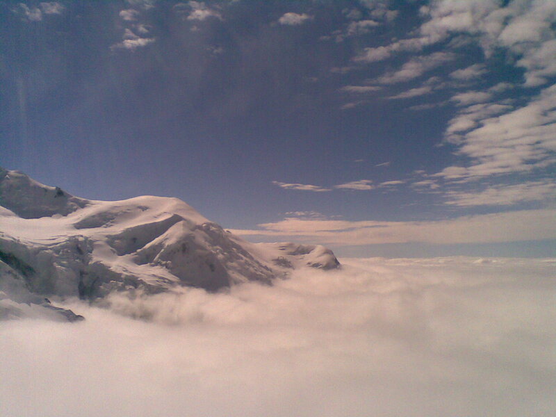 Snowy mountain above clouds