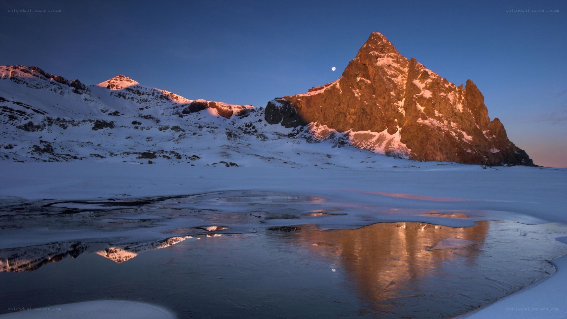 Snowy mountain at dusk with moon