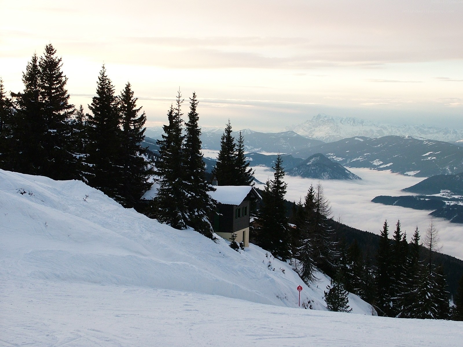 Snowy mountain cabin at dawn
