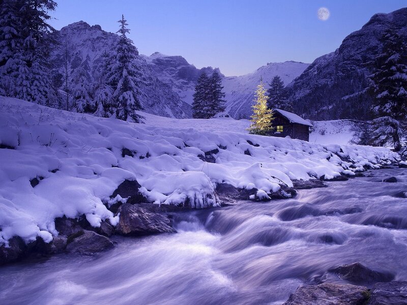 Snowy mountain cabin at night