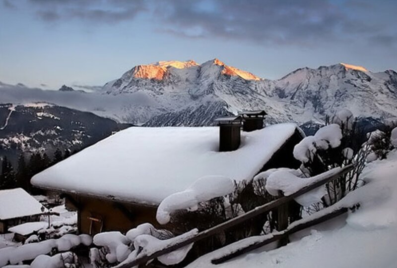 Snowy mountain cabin at sunrise