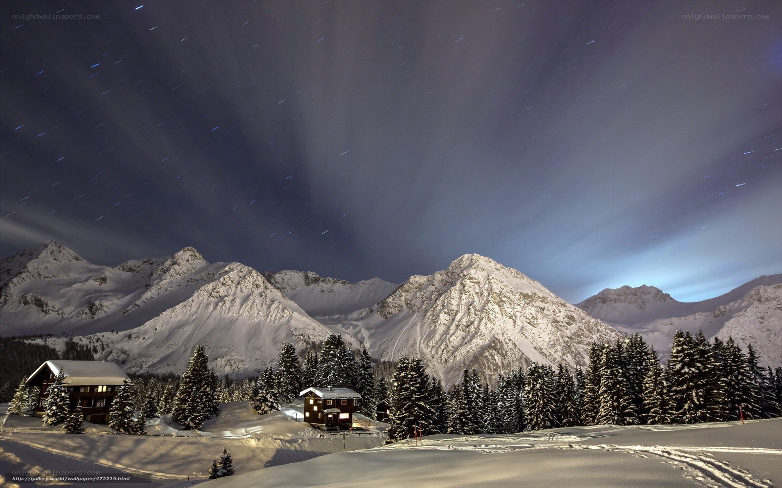 Snowy mountain cabin under star trails