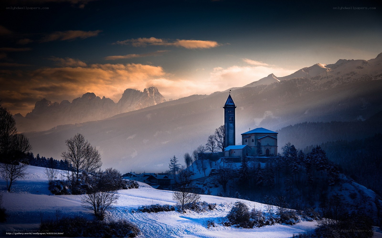 Snowy mountain church at sunset