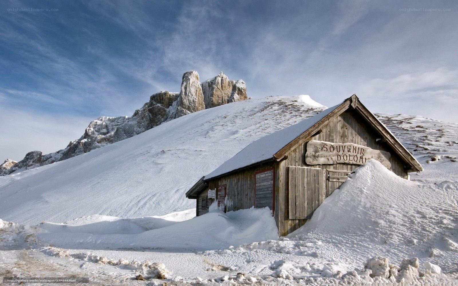 Snowy mountain hut with Dolomites