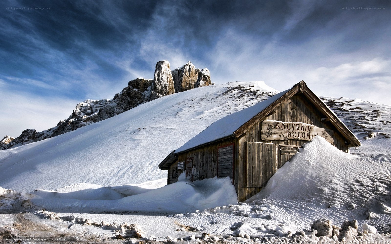 Snowy mountain hut with rocky peak