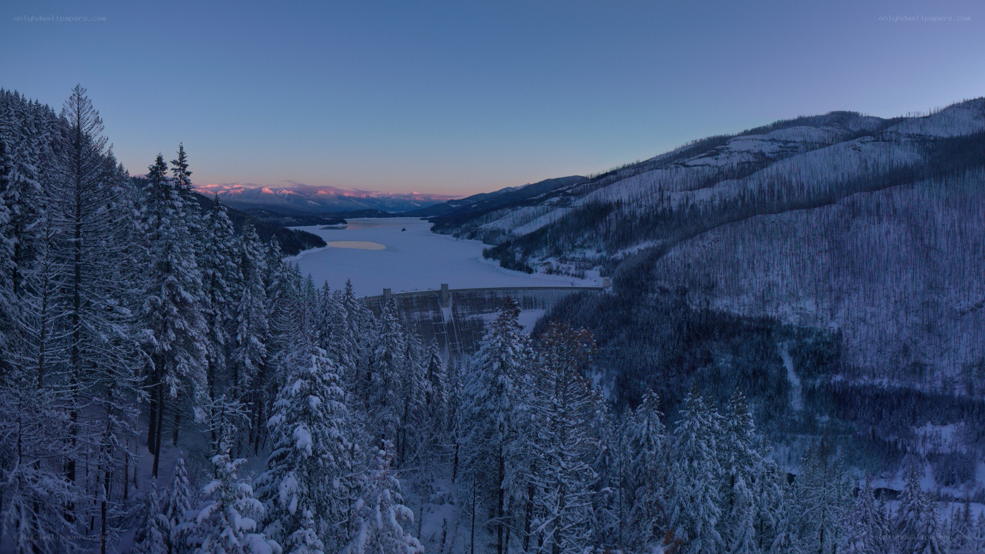 Snowy mountain lake at dusk