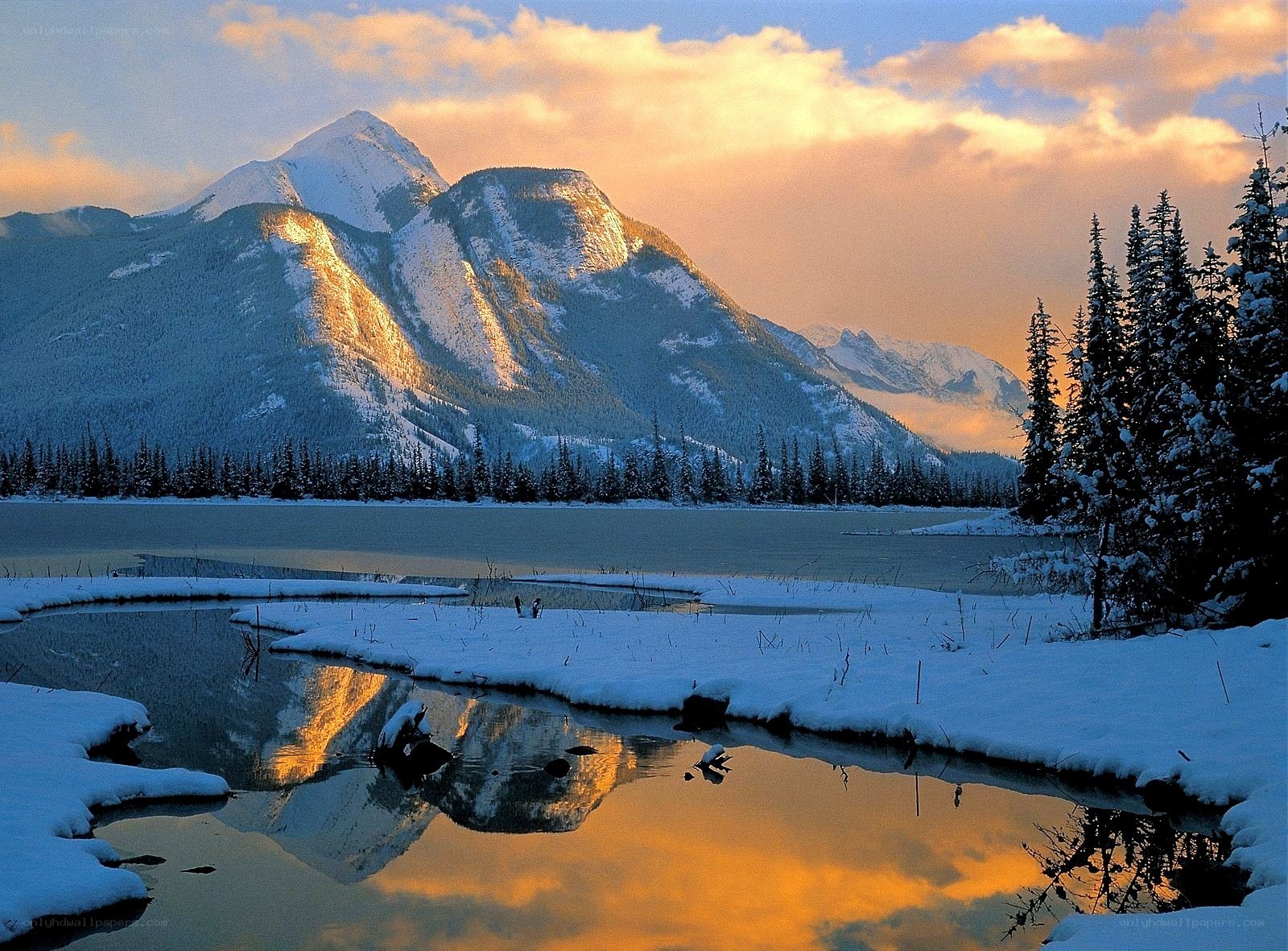 Snowy mountain lake at sunset