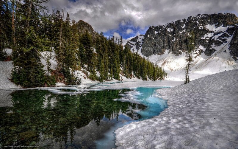 Snowy mountain lake in spring