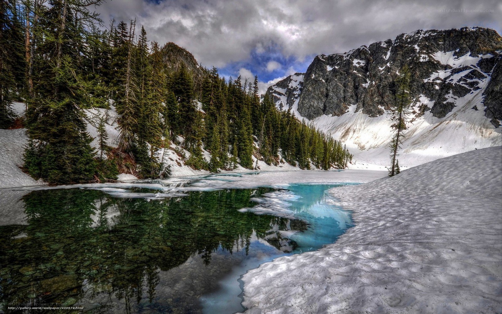 Snowy mountain lake in spring