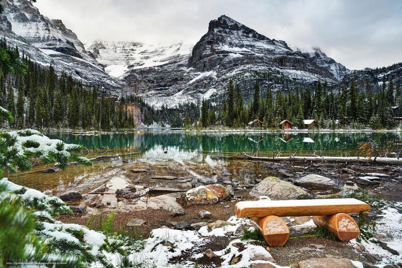 Snowy mountain lake with cabin