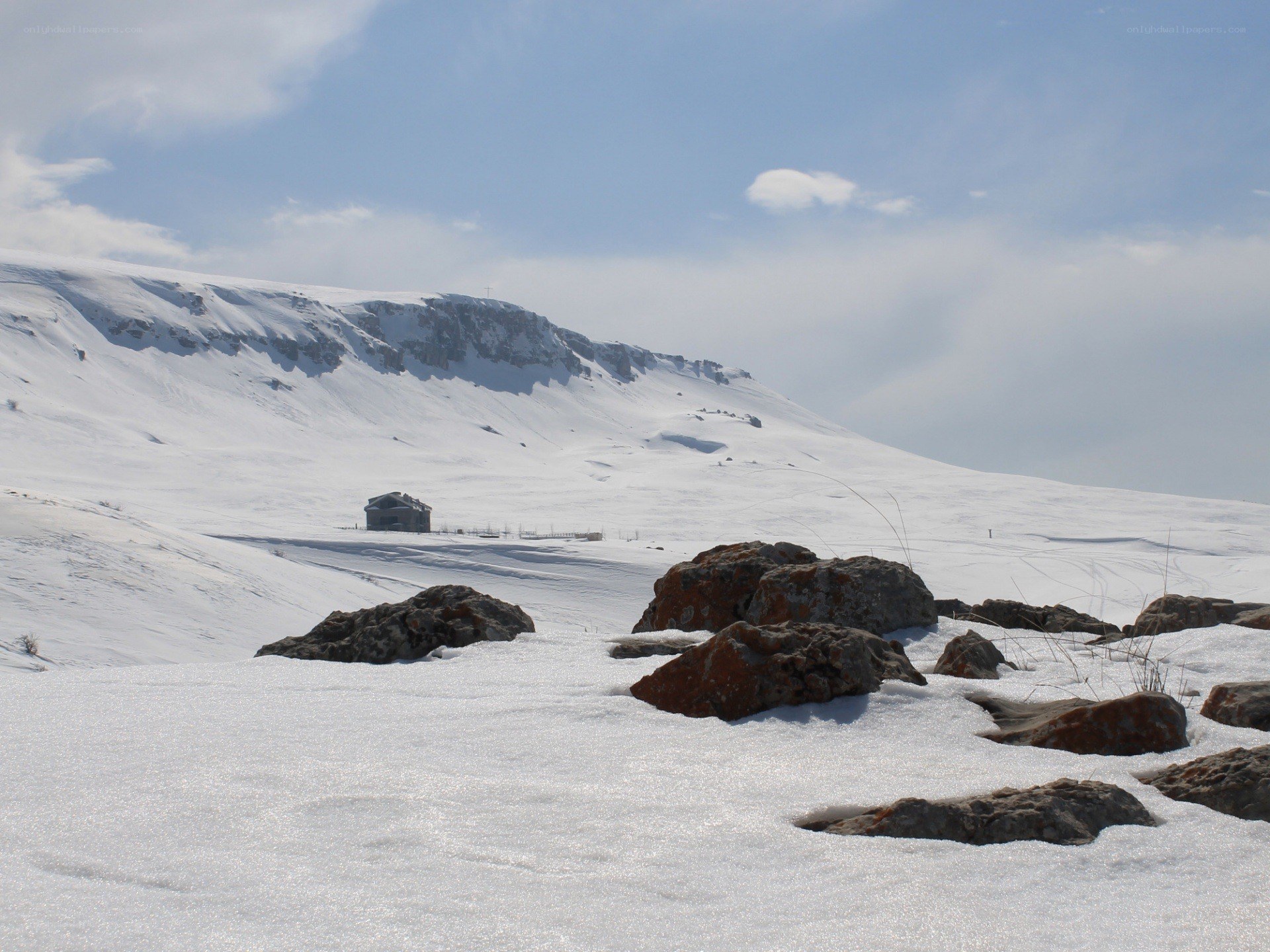 Snowy mountain landscape with cabin