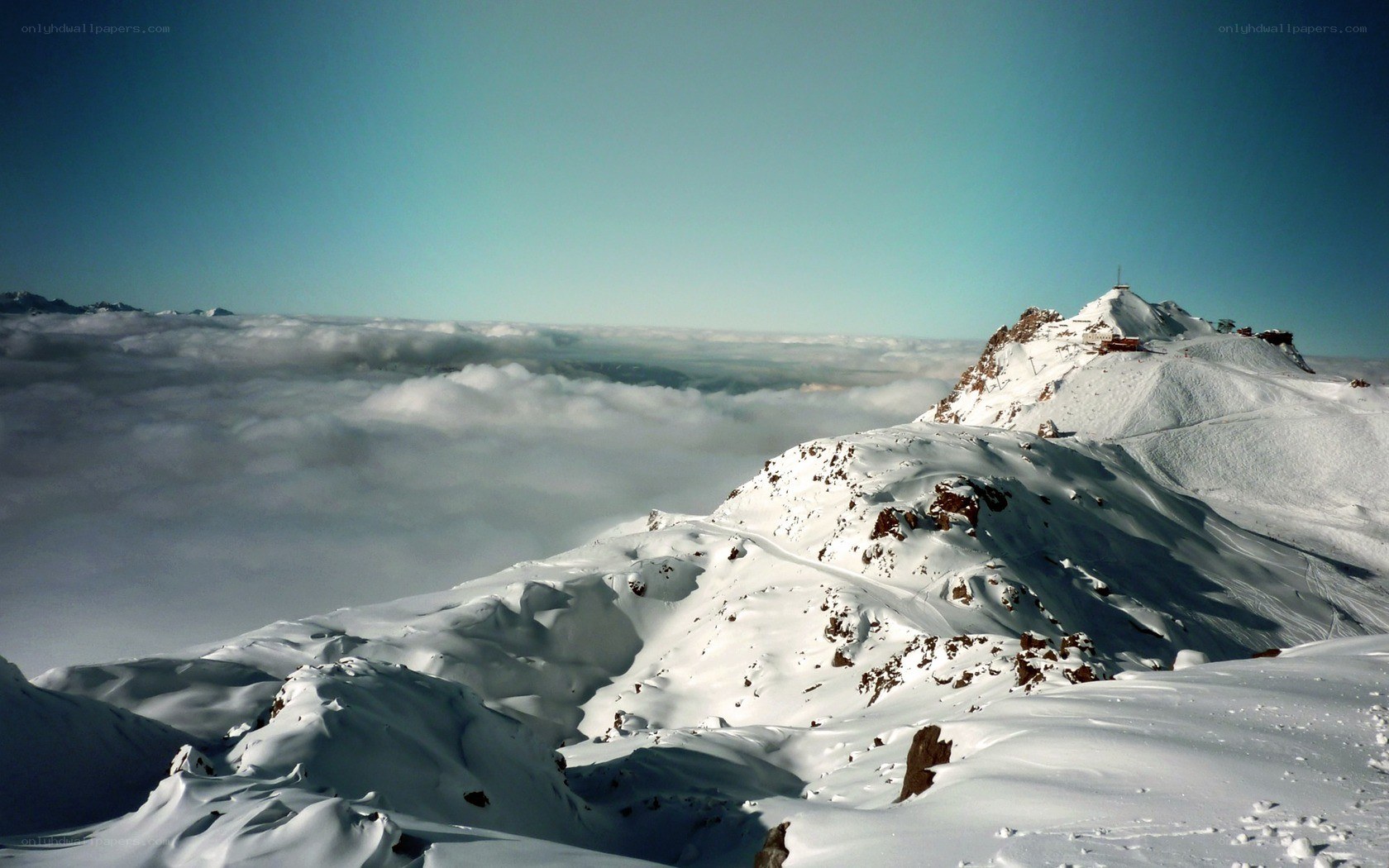 snowy mountain peak above clouds