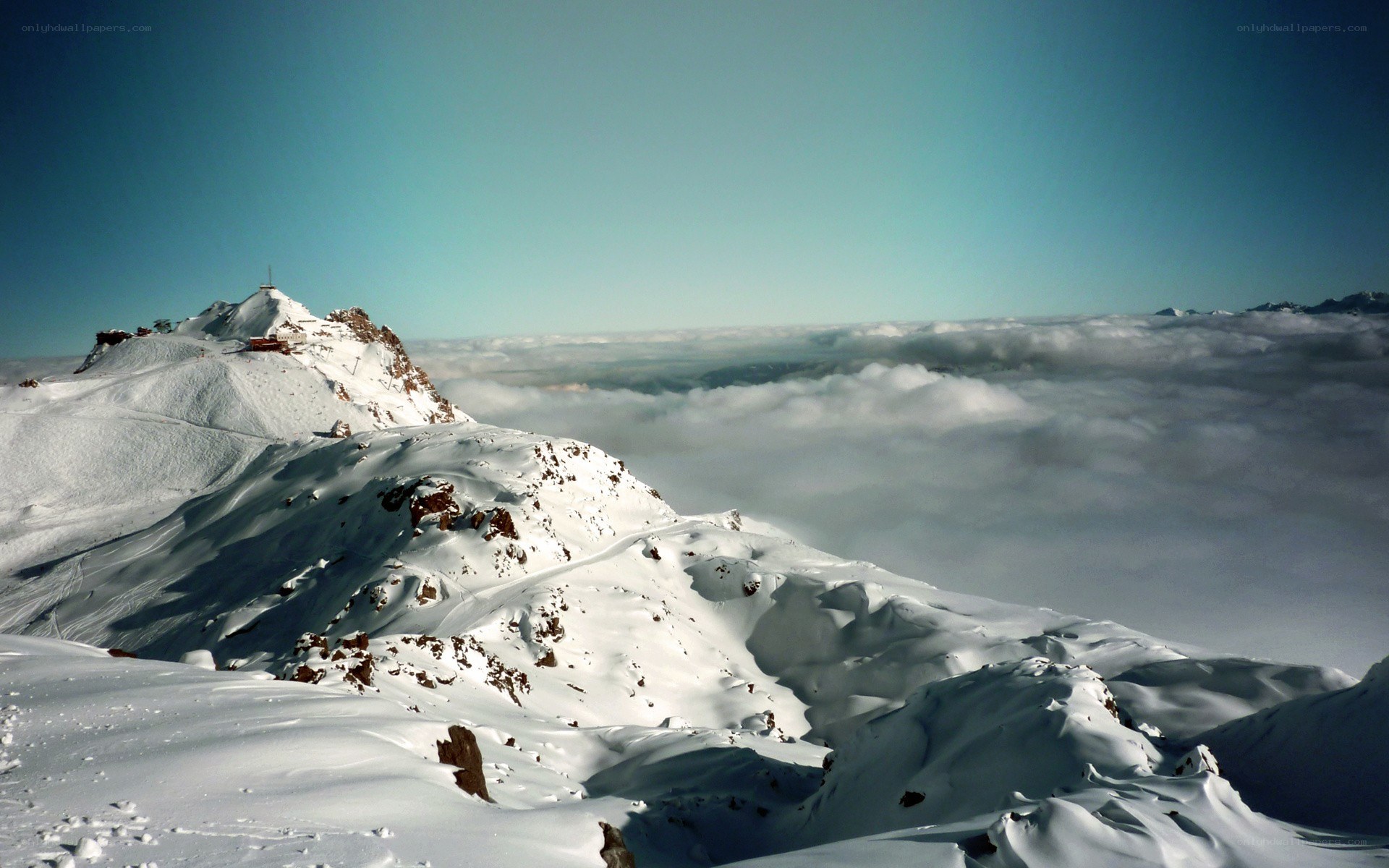 snowy mountain peak above clouds