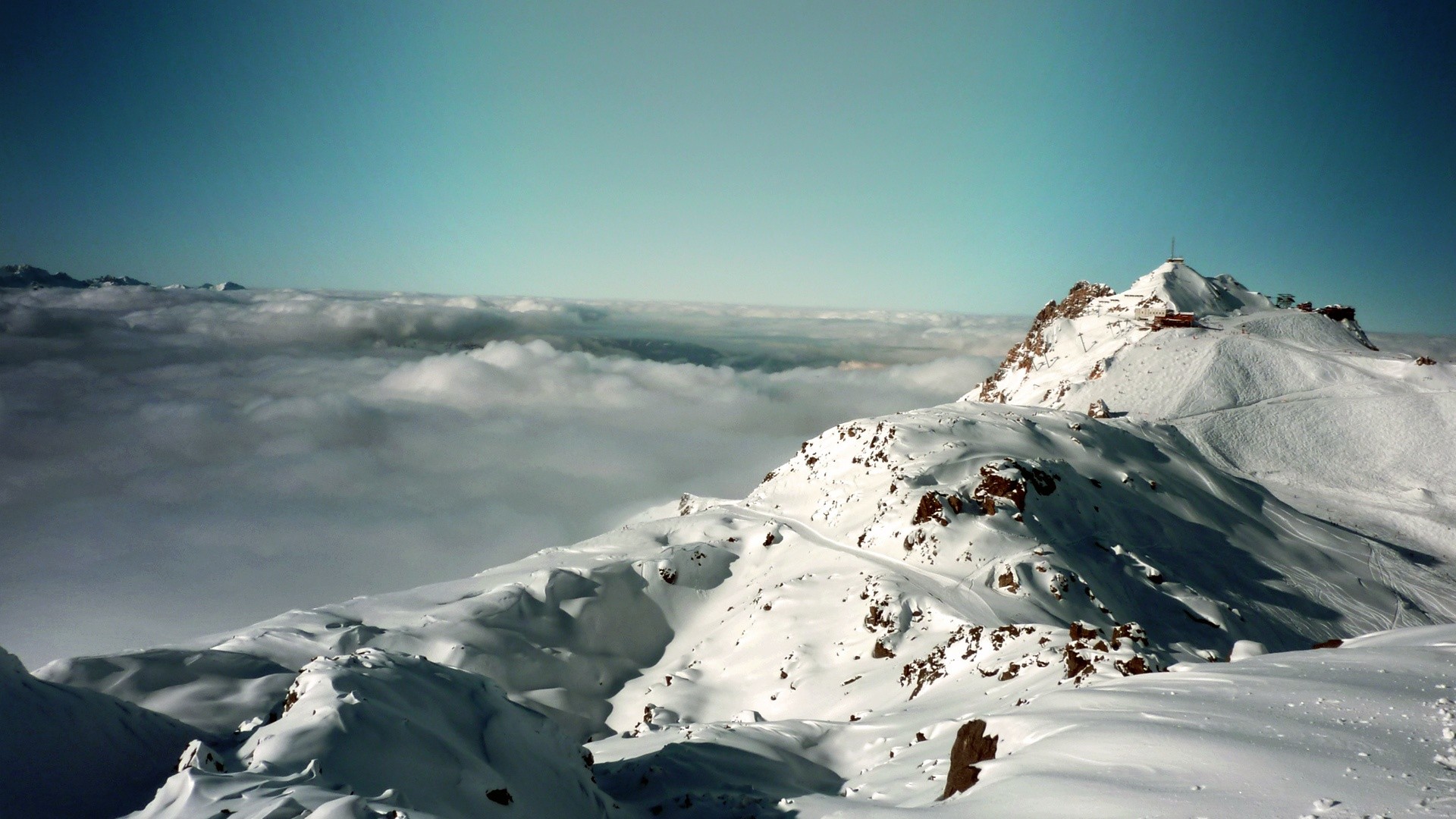 Snowy mountain peak above clouds