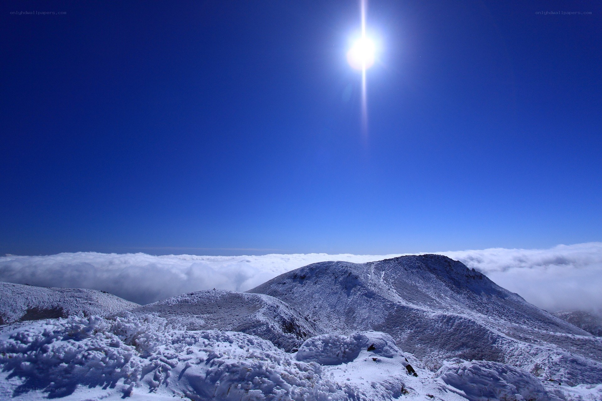 Snowy mountain peak above clouds