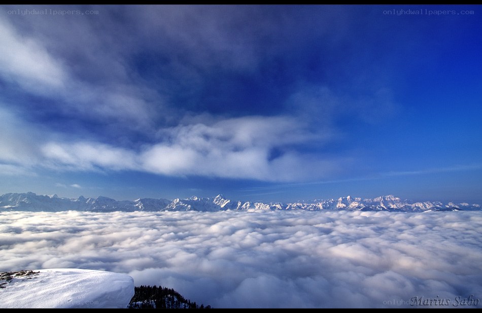 Snowy mountain peak above clouds