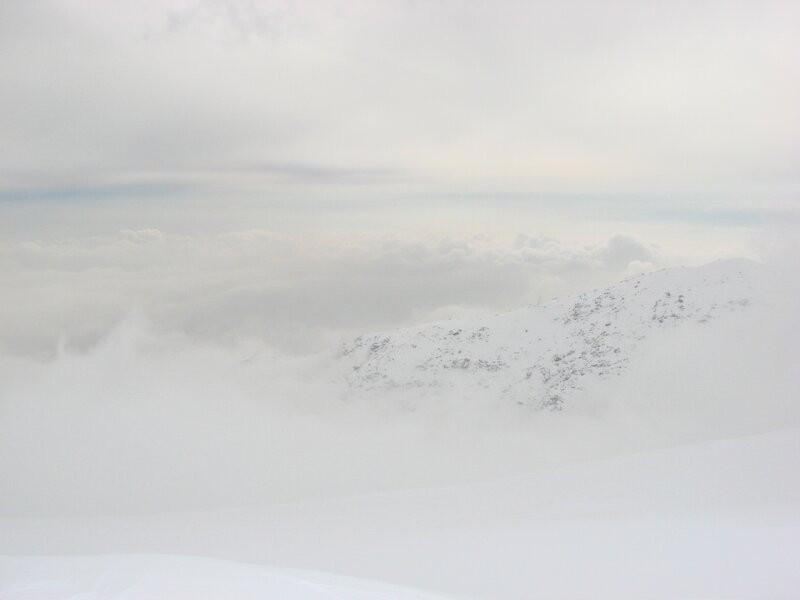 snowy mountain peak above clouds