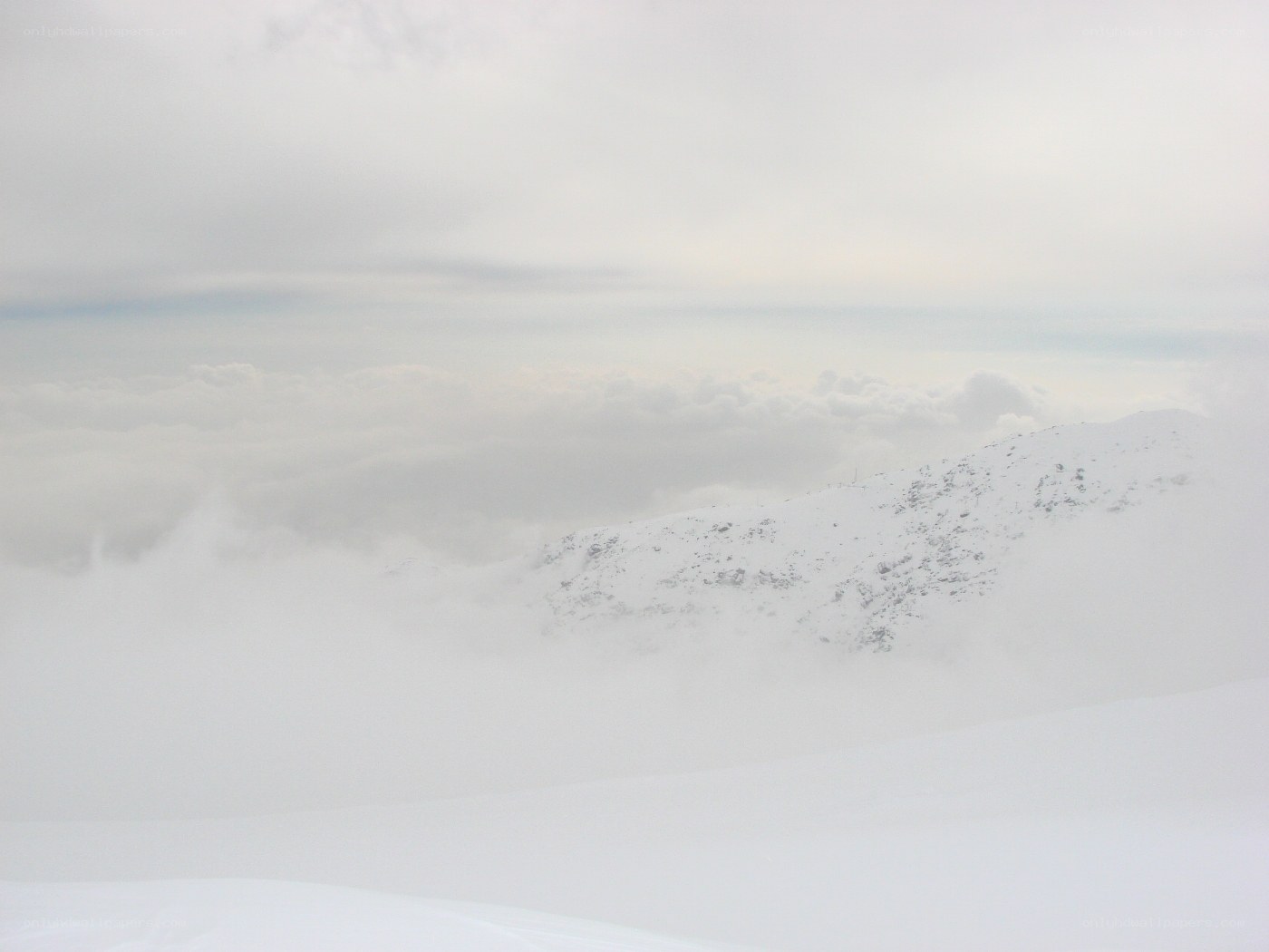 snowy mountain peak above clouds