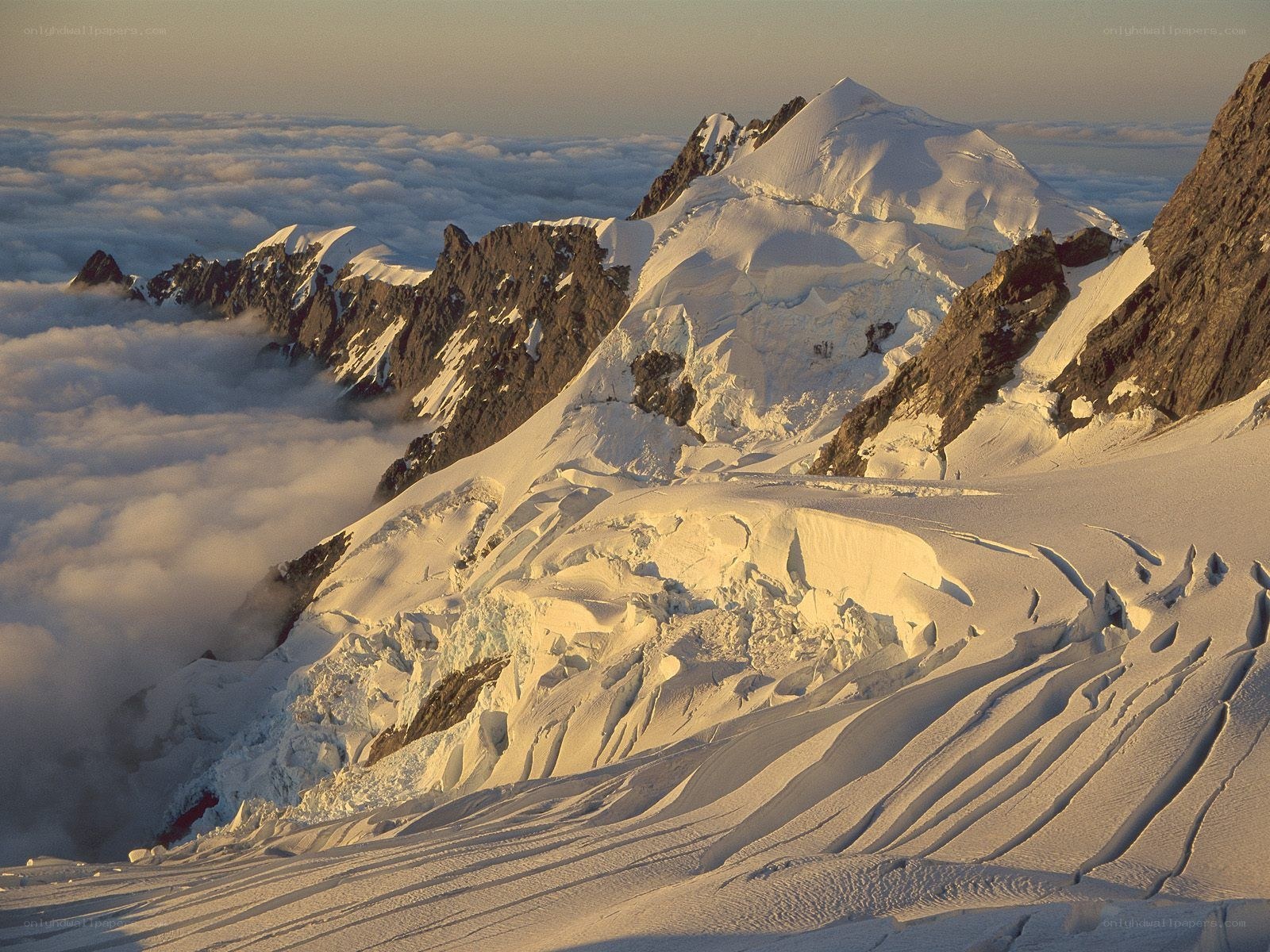 Snowy mountain peak above clouds