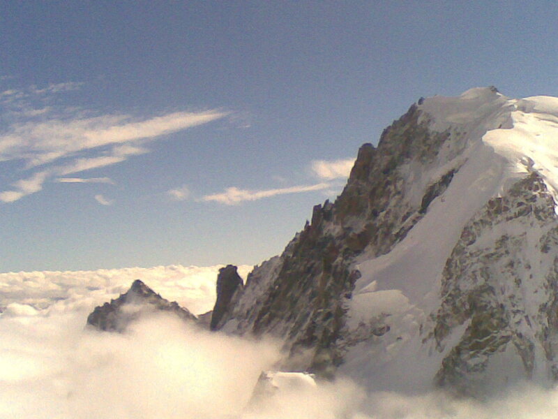 Snowy mountain peak above clouds
