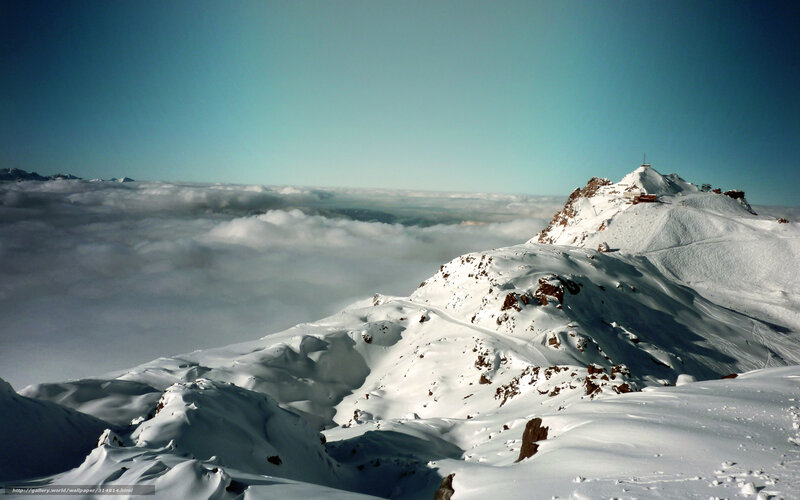 Snowy mountain peak above clouds