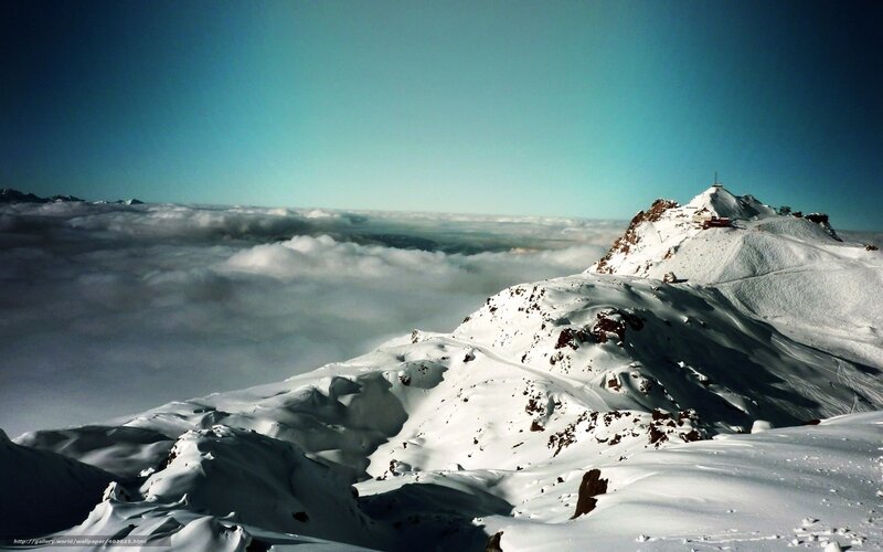 Snowy mountain peak above clouds