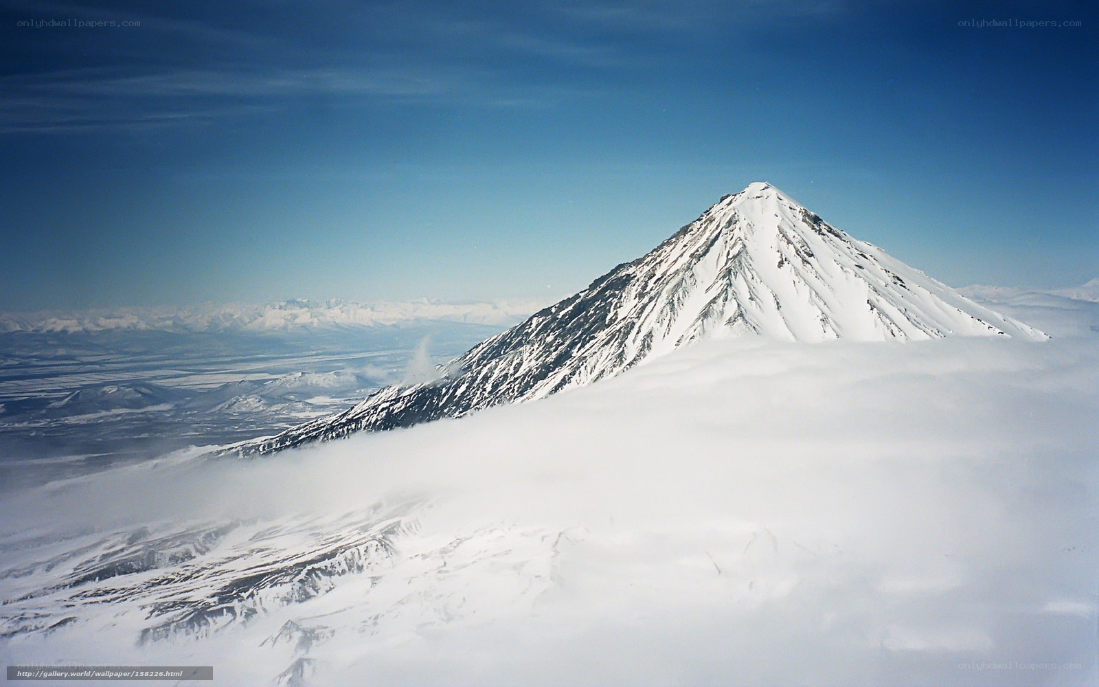Snowy mountain peak above clouds