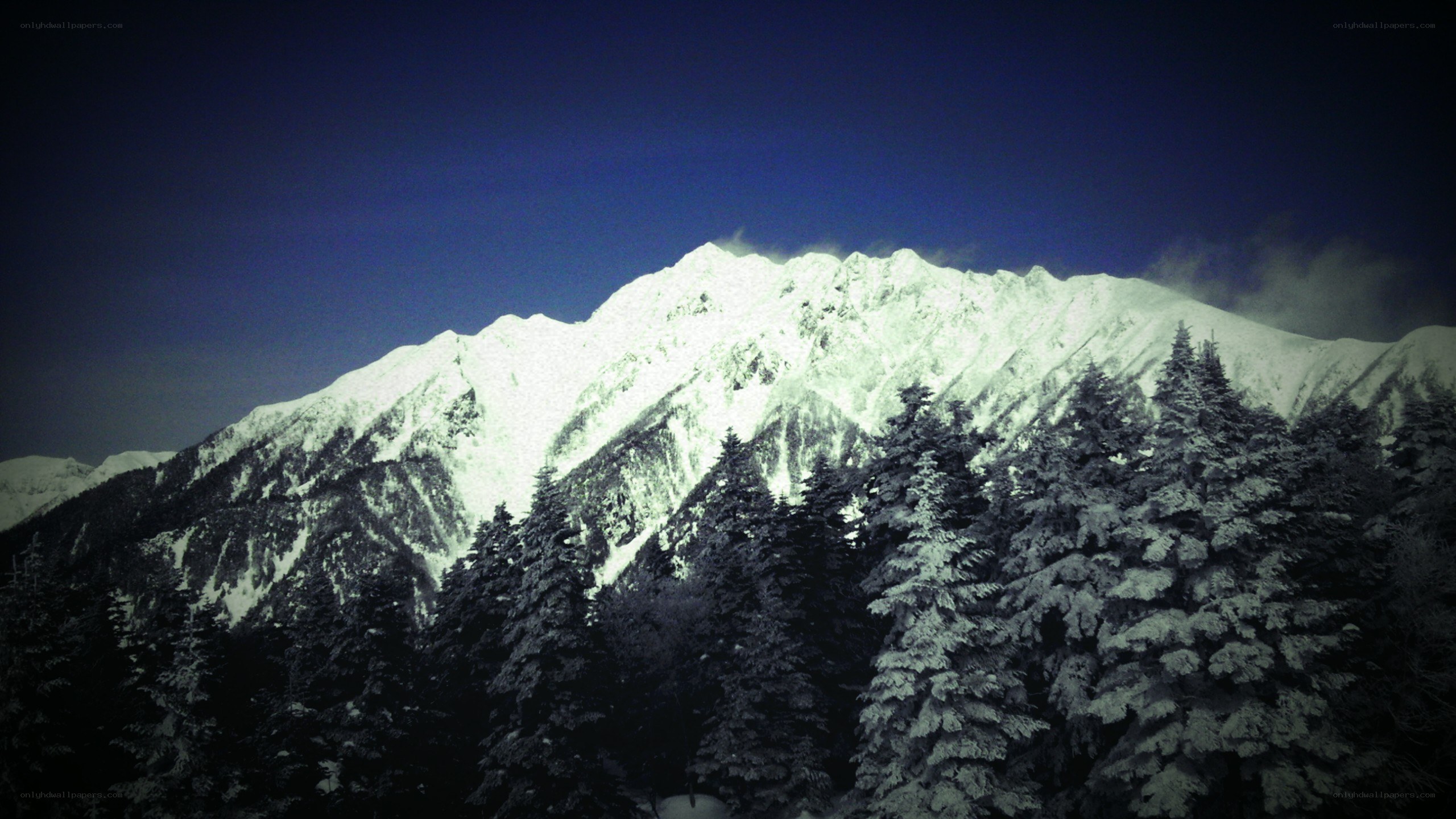 Snowy mountain peak at night