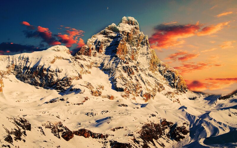 Snowy mountain peak at sunset