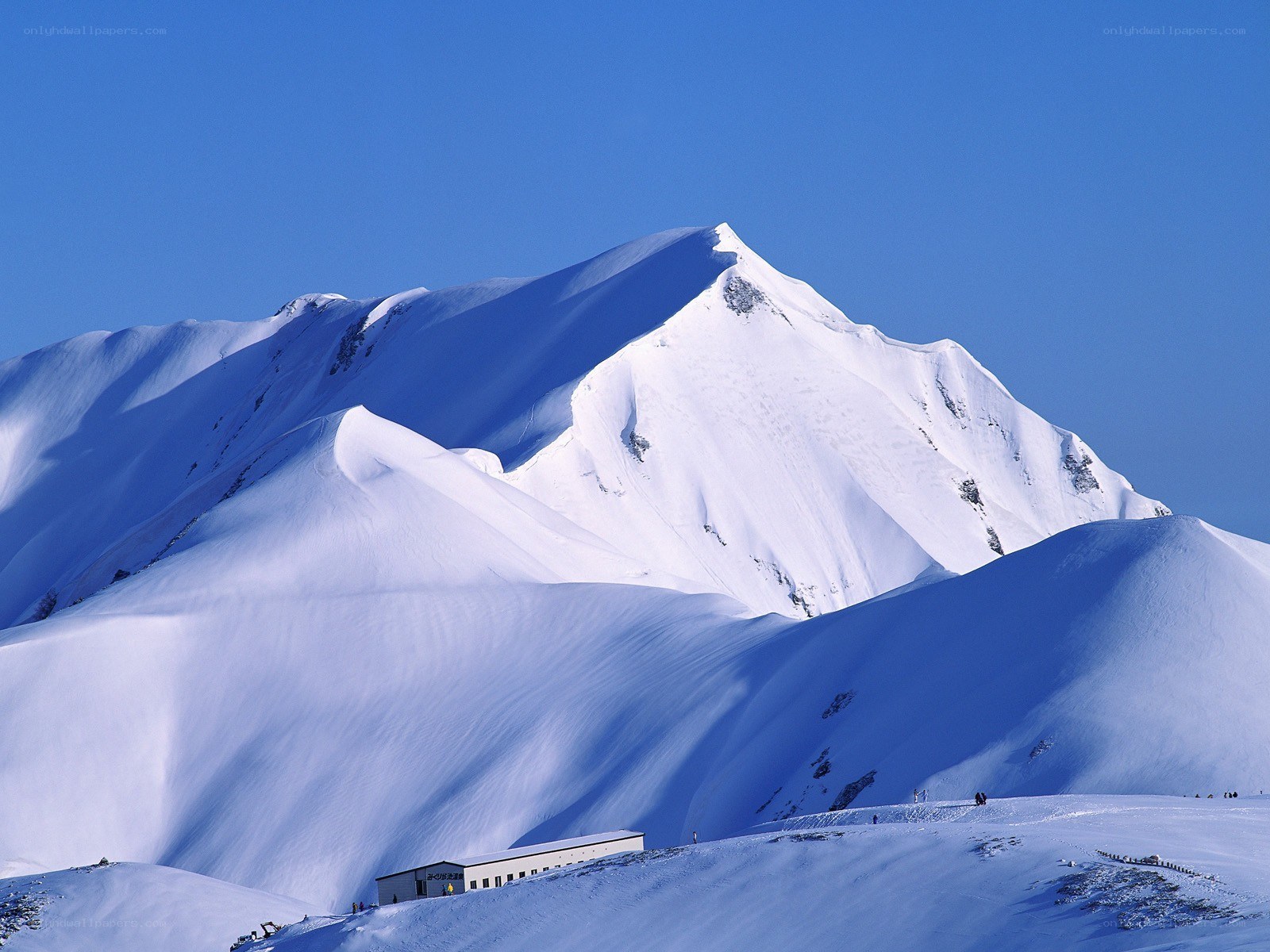 Snowy mountain peak under blue sky